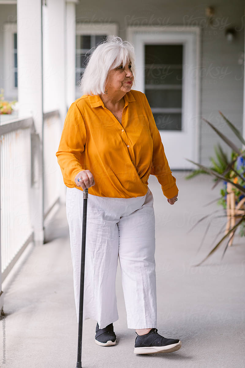 Elderly woman wearing walking stick in retired housing apartment
