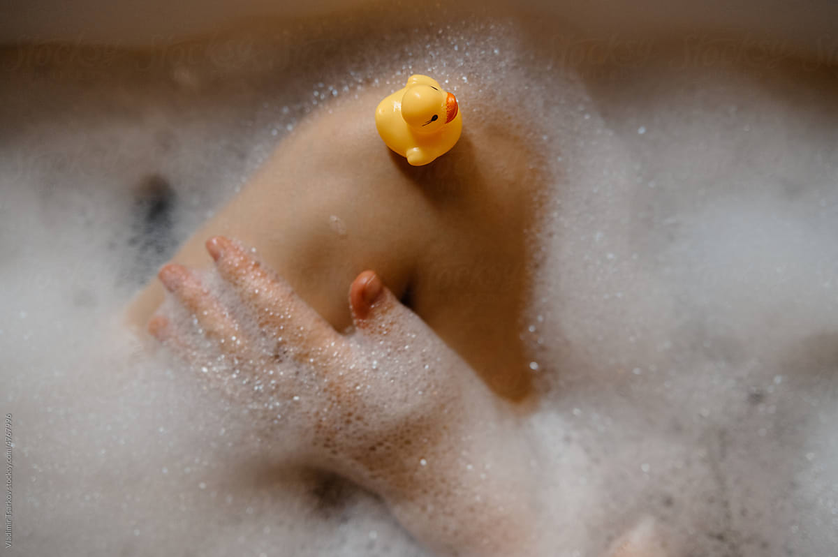 Anonymous woman taking bath with rubber duck