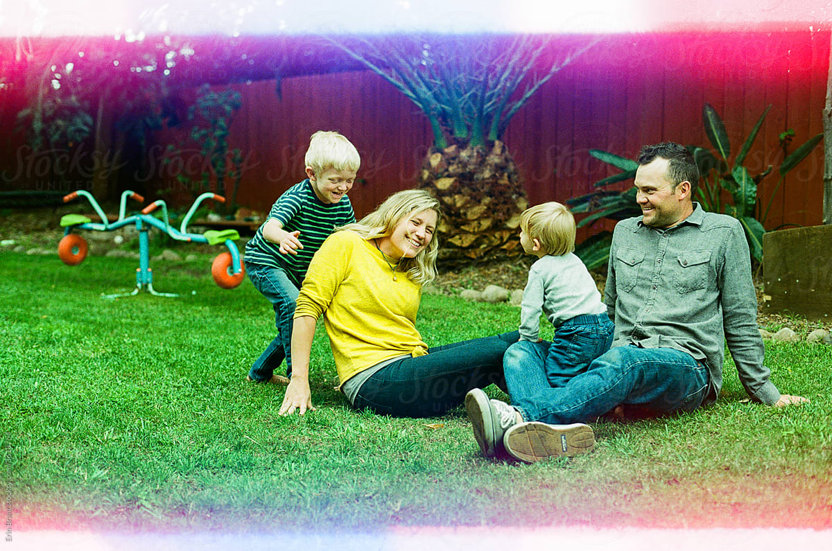 Laughing family playing on the ground in backyard