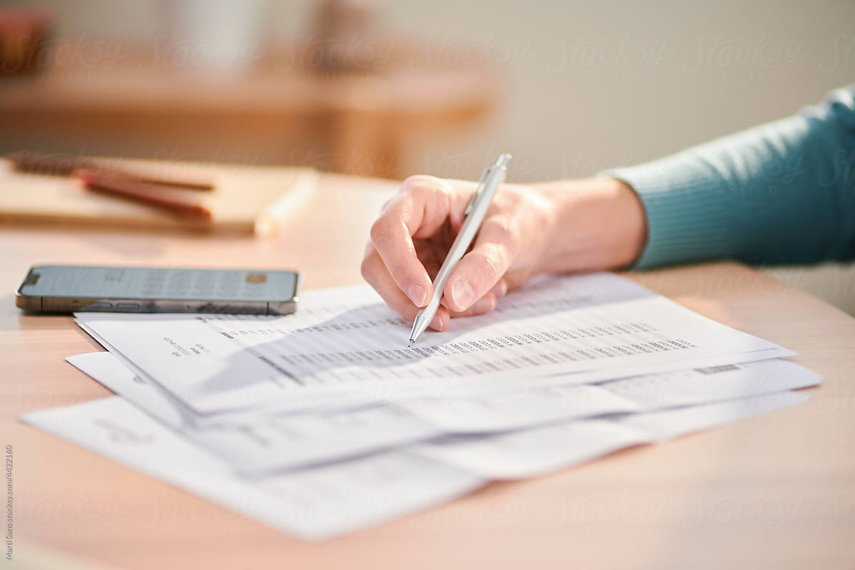Woman taking notes and paying bills at home