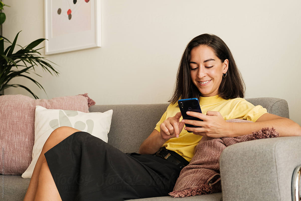Woman using phone sitting at home