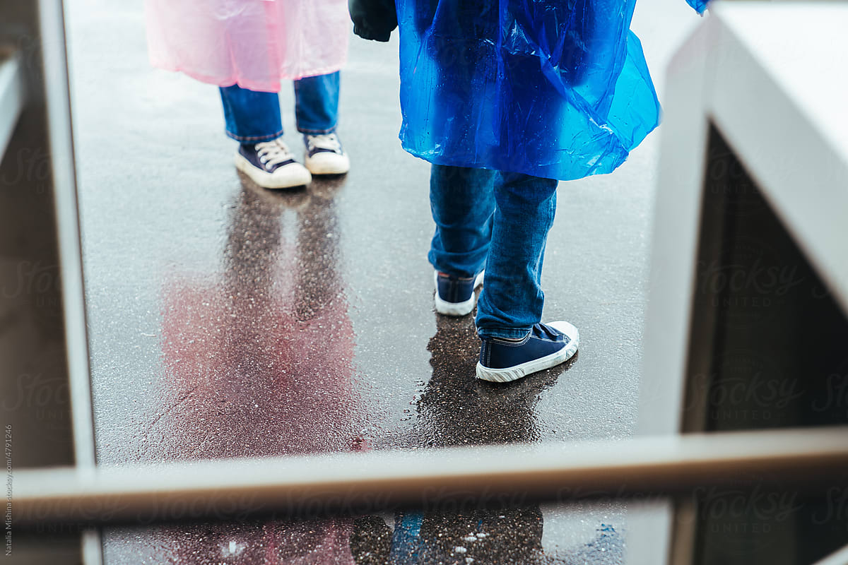 Raincoats, feet on wet asphalt.