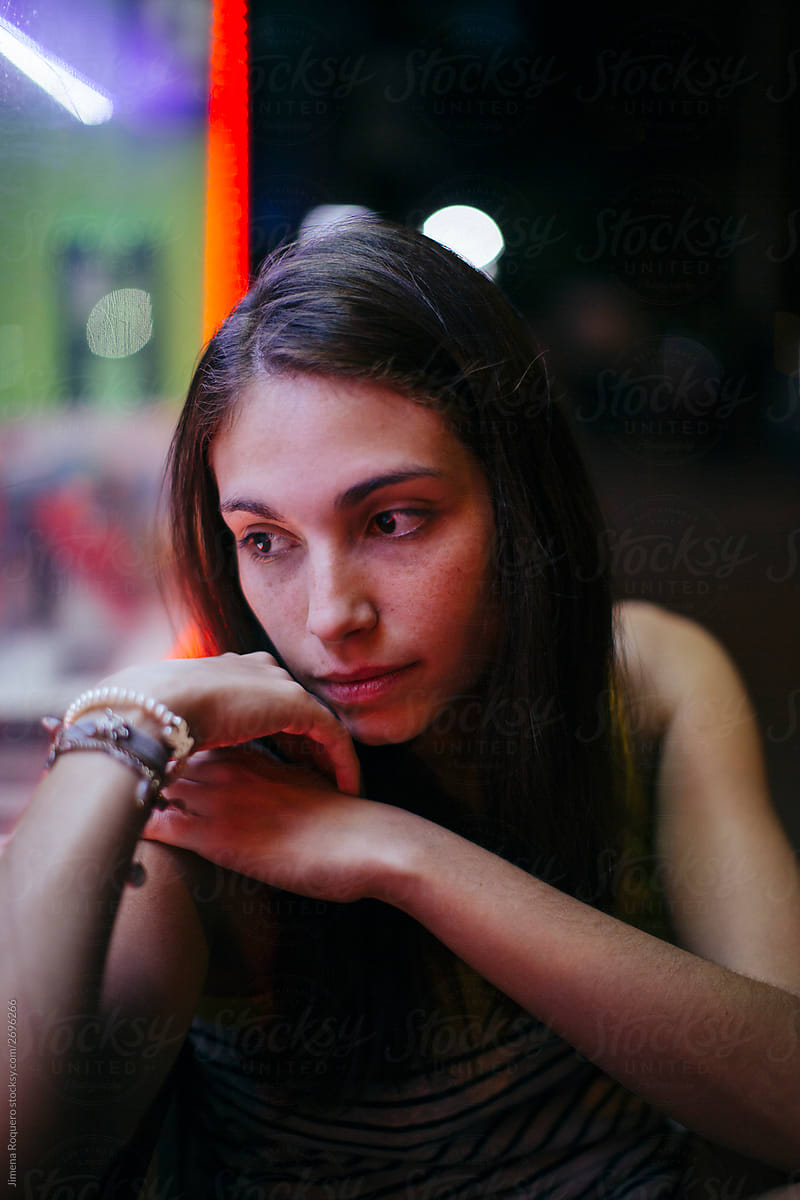 Pretty young girl looking to the left on neon pink lights