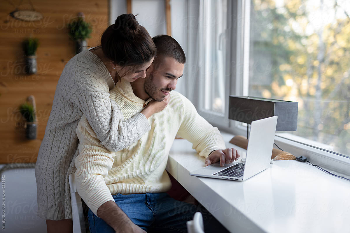 Young couple at home using laptop