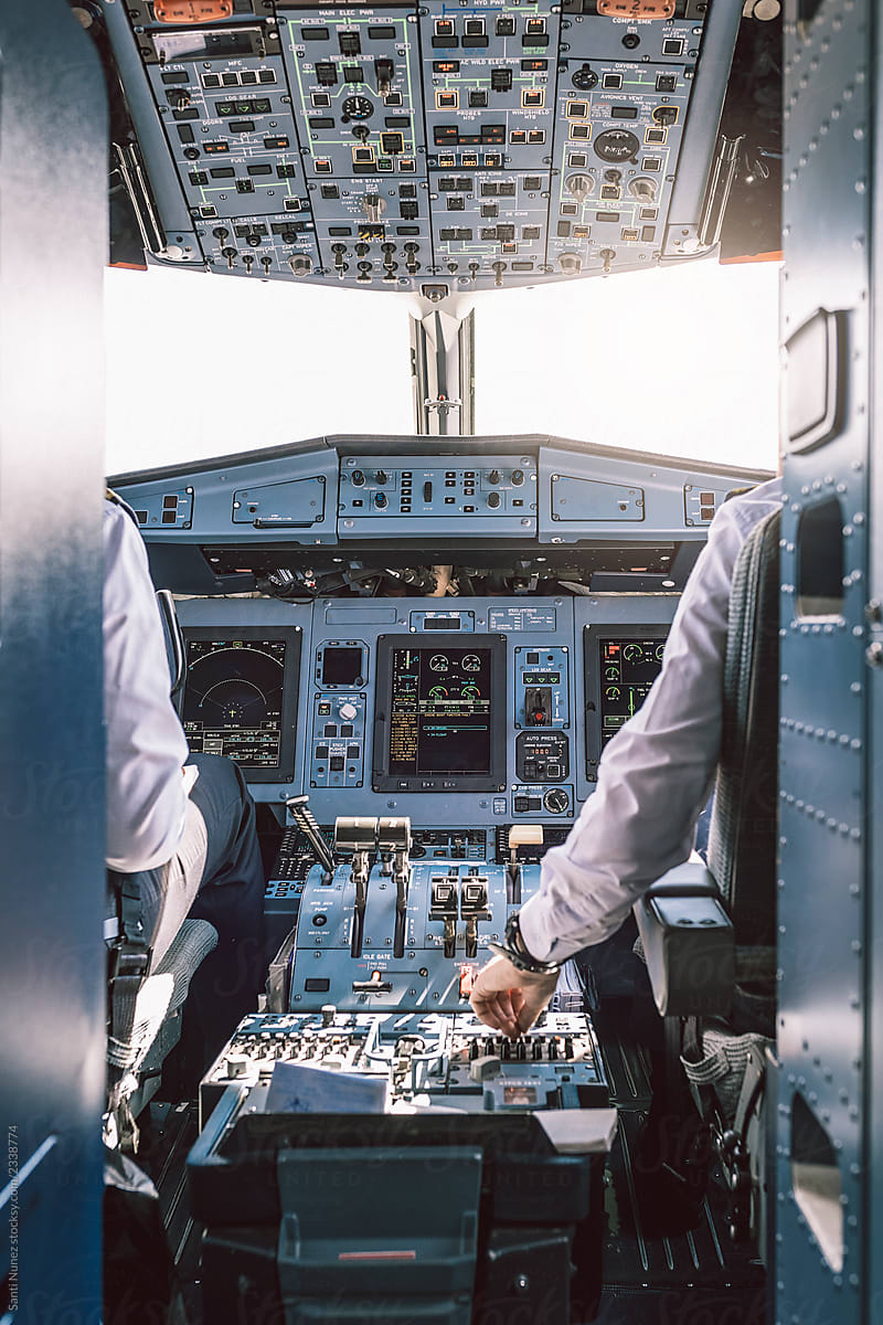 Pilot and copilot inside a cabin flying an airplane