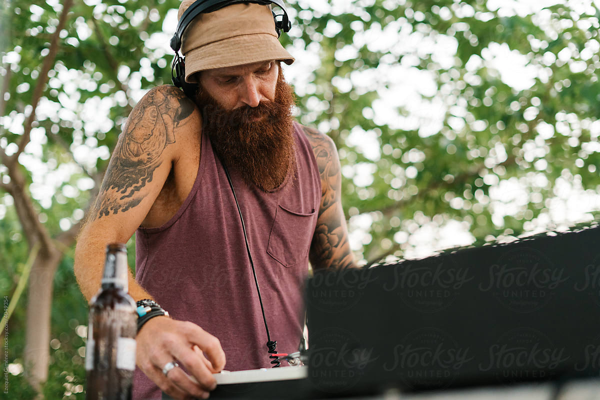 Red-headed DJ mixing in the park during the daytime