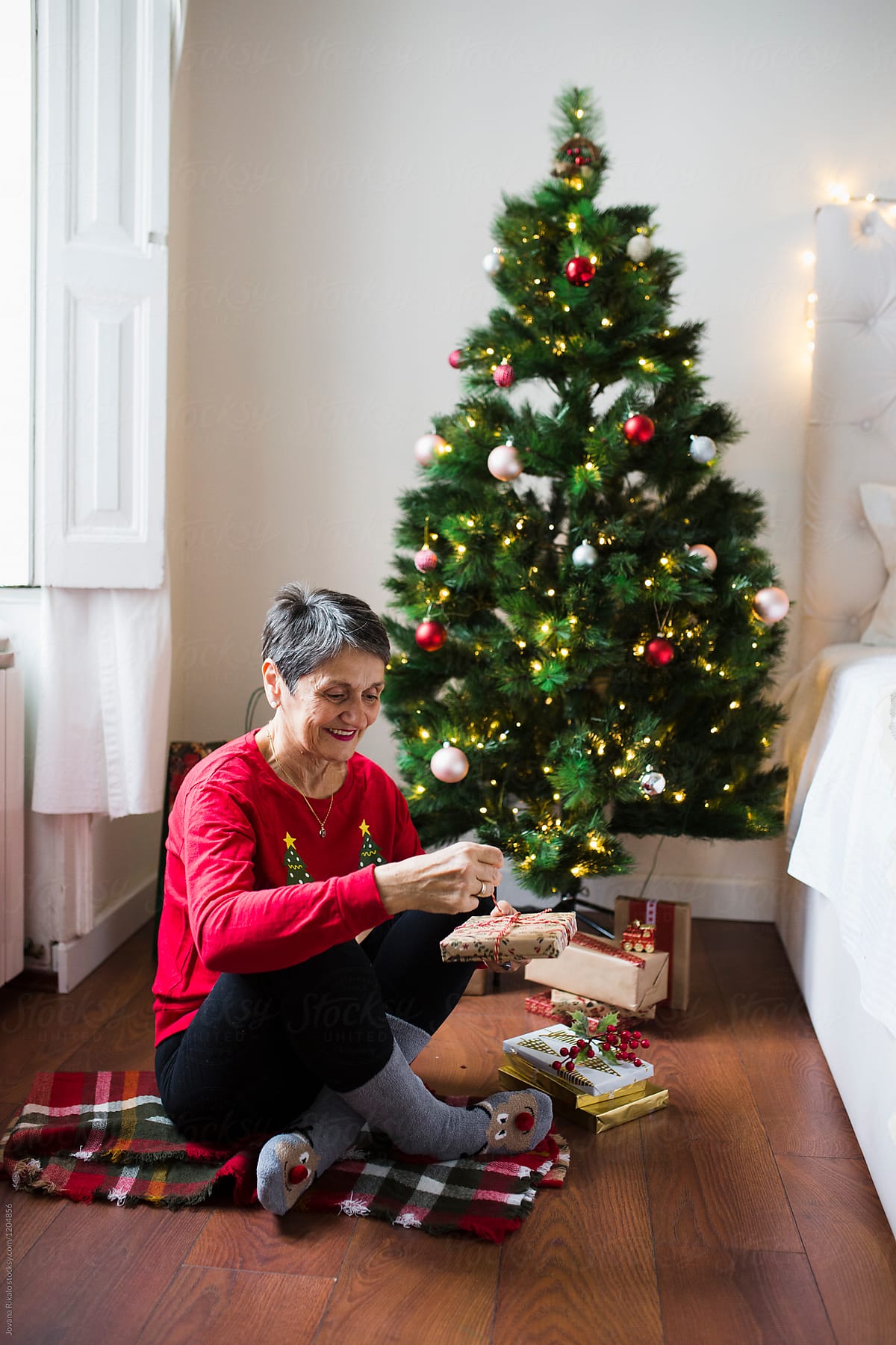 Elderly Woman Opening Christmas Gifts by Stocksy Contributor Jovana  Rikalo - Stocksy