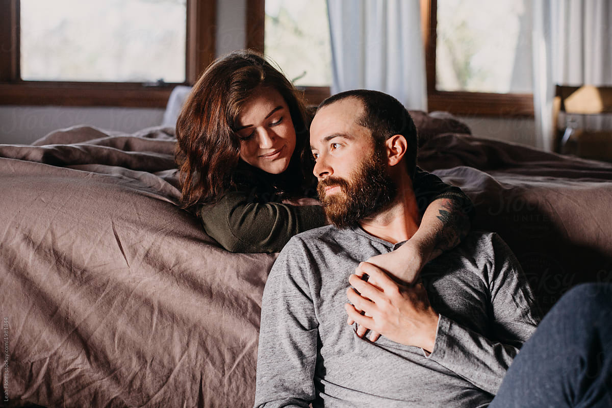 Couple Cuddled At Foot Of Bed By Stocksy Contributor Leah Flores Stocksy