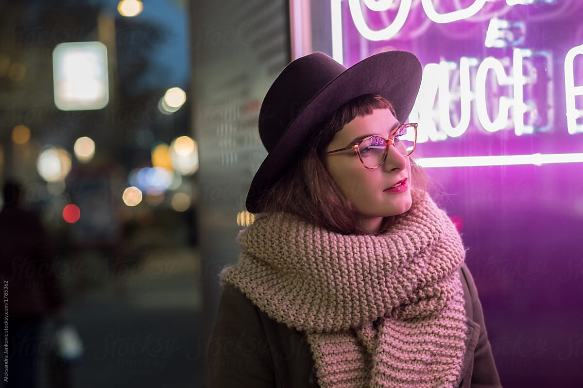 Stylish Young Woman Looking At The Shop Window With Neon Sign