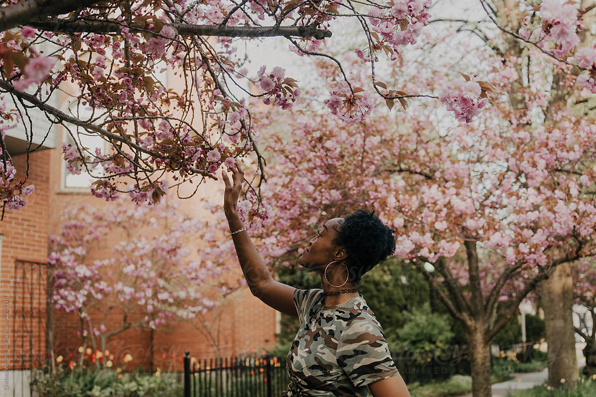 A young african american woman waking down a street in the spring