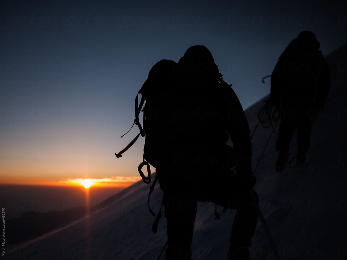 Mountaineers silhouettes with sunrise in the backgound