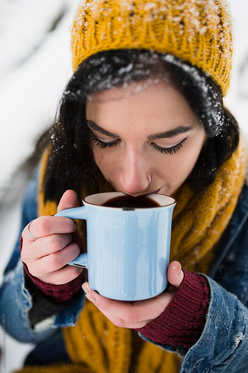 Young woman drinking mulled wine in snow
