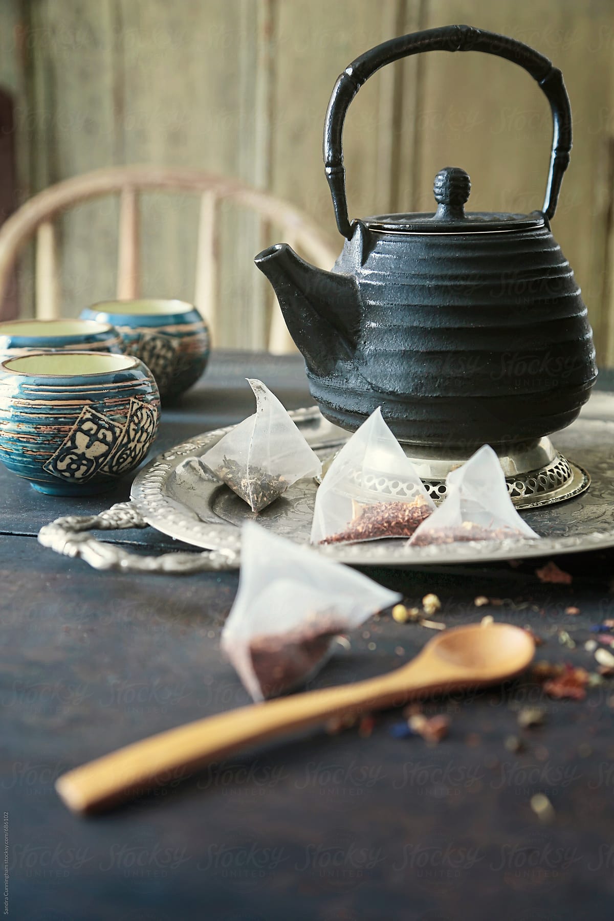Asian teapot with cups and tea leave sachets