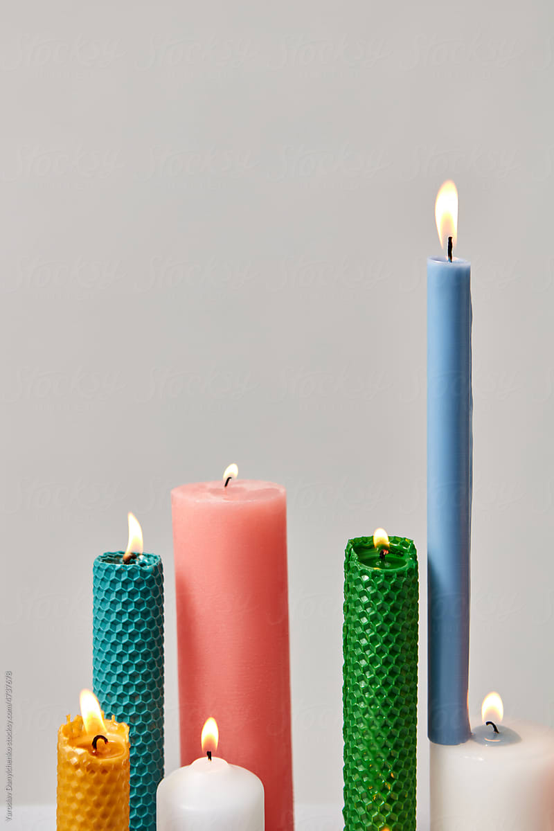 Burning multi-colored candles in various shapes.