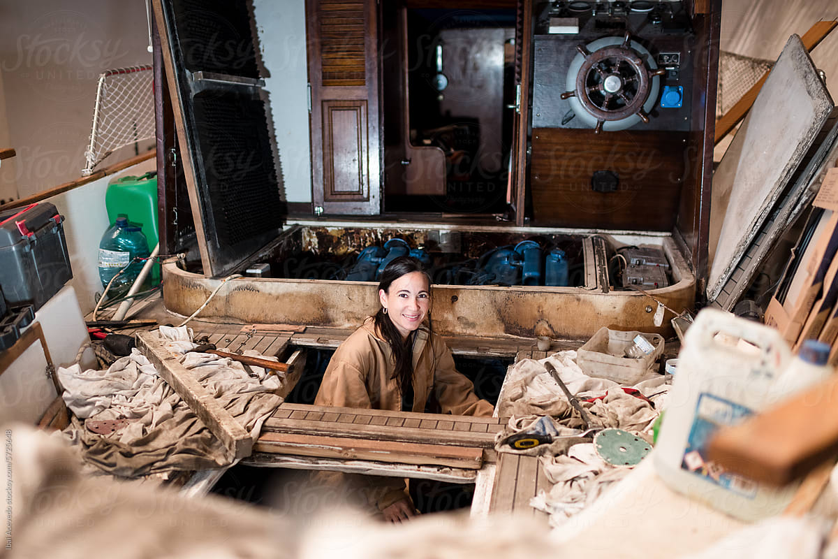 Smiling woman working on boat restoration