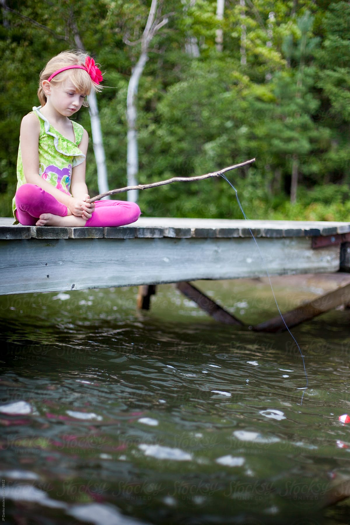 Little Girl Fishing With Worm From Cottage Lake Dock