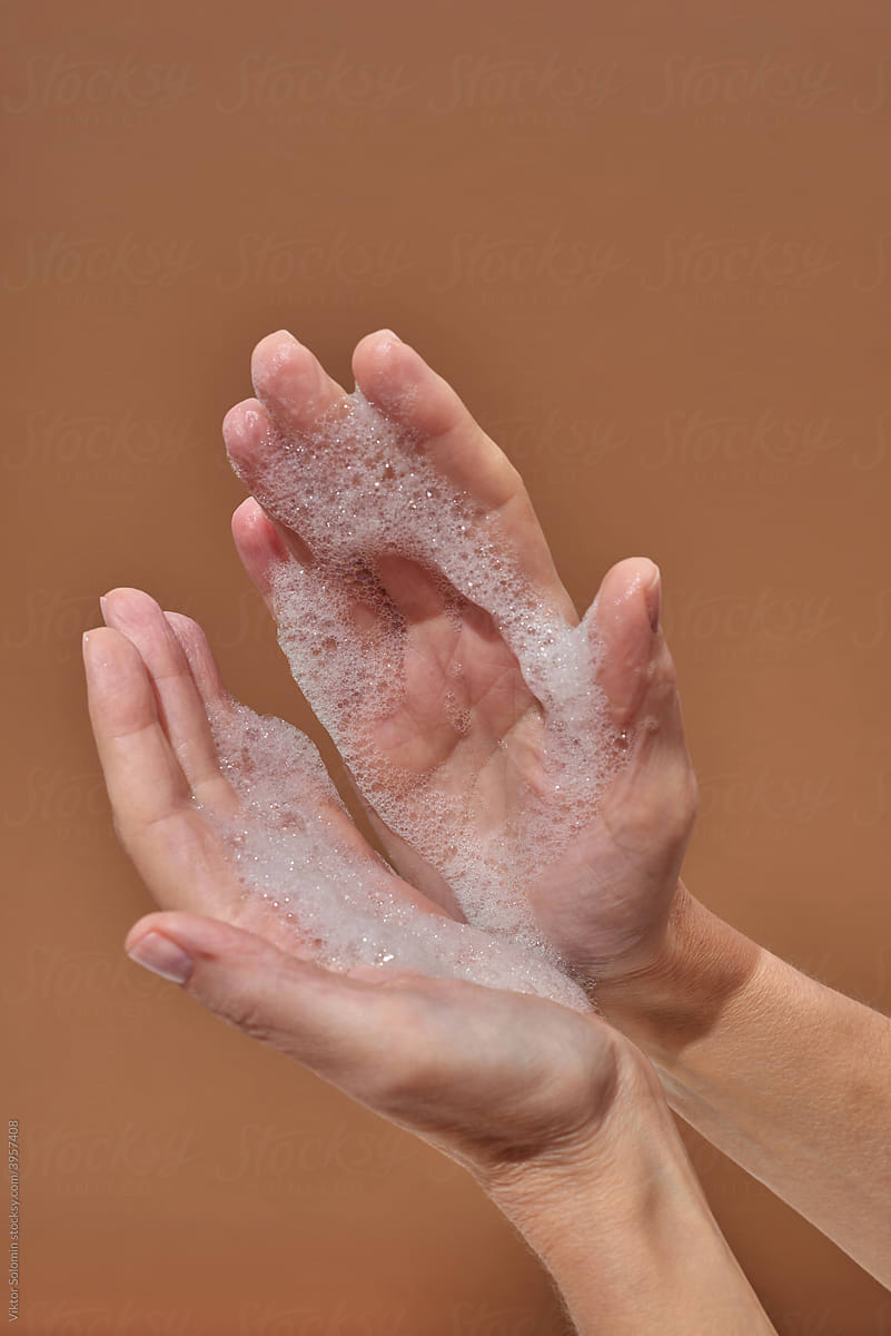 Crop woman showing foamy hands