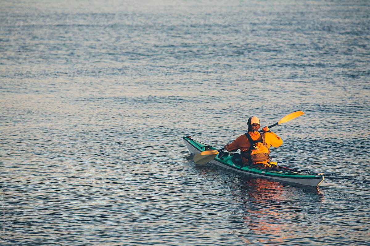 Man sea kayaking in Puget Sound at dusk