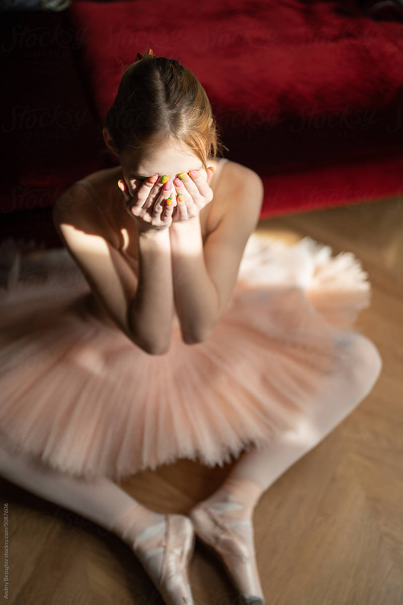 Sun shines onto female ballet dancer in hotel room