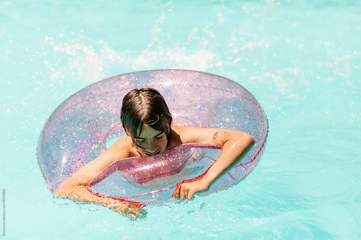Teenager with ring float in pool