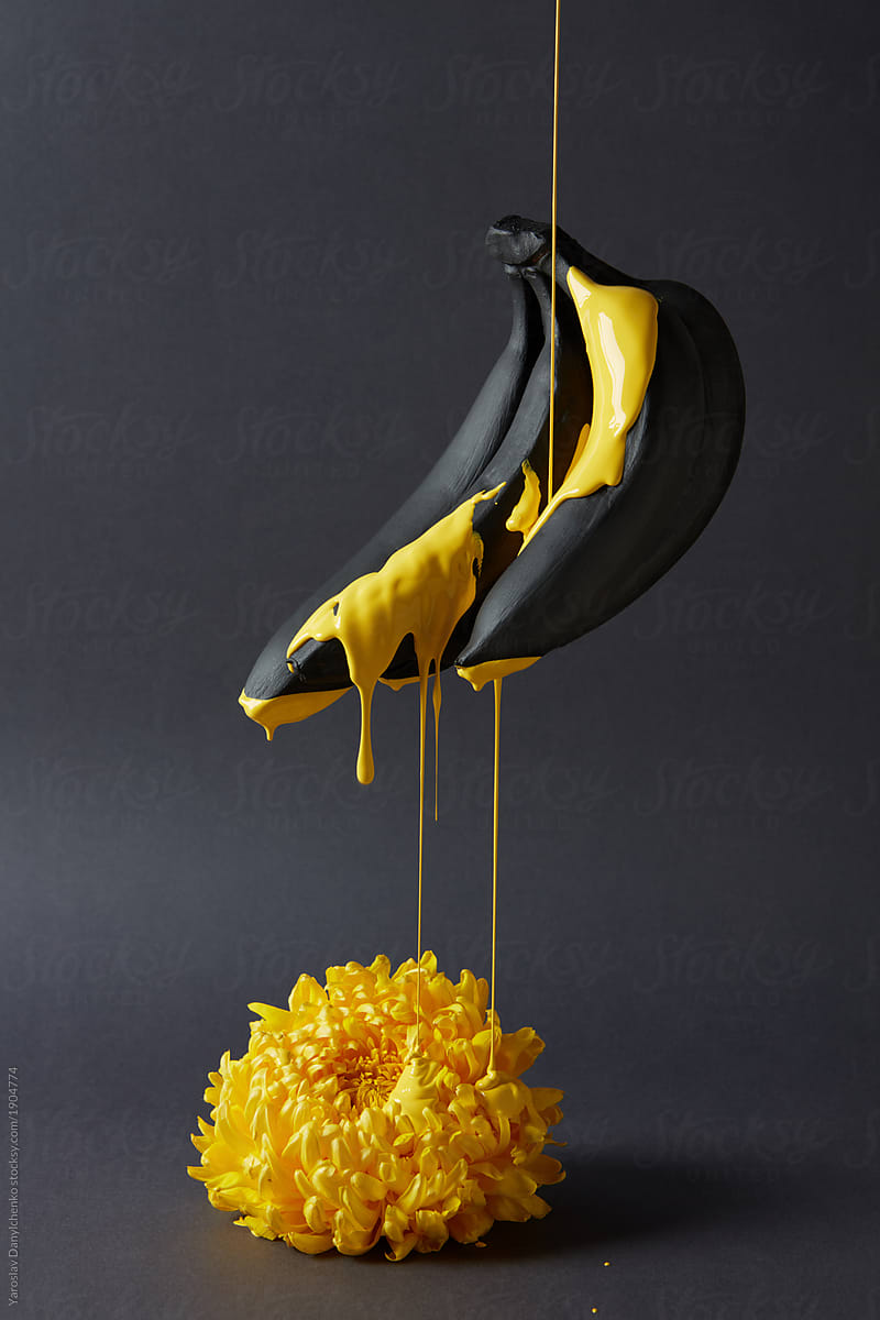Chrysanthemum and bananas with yellow paint on a black background