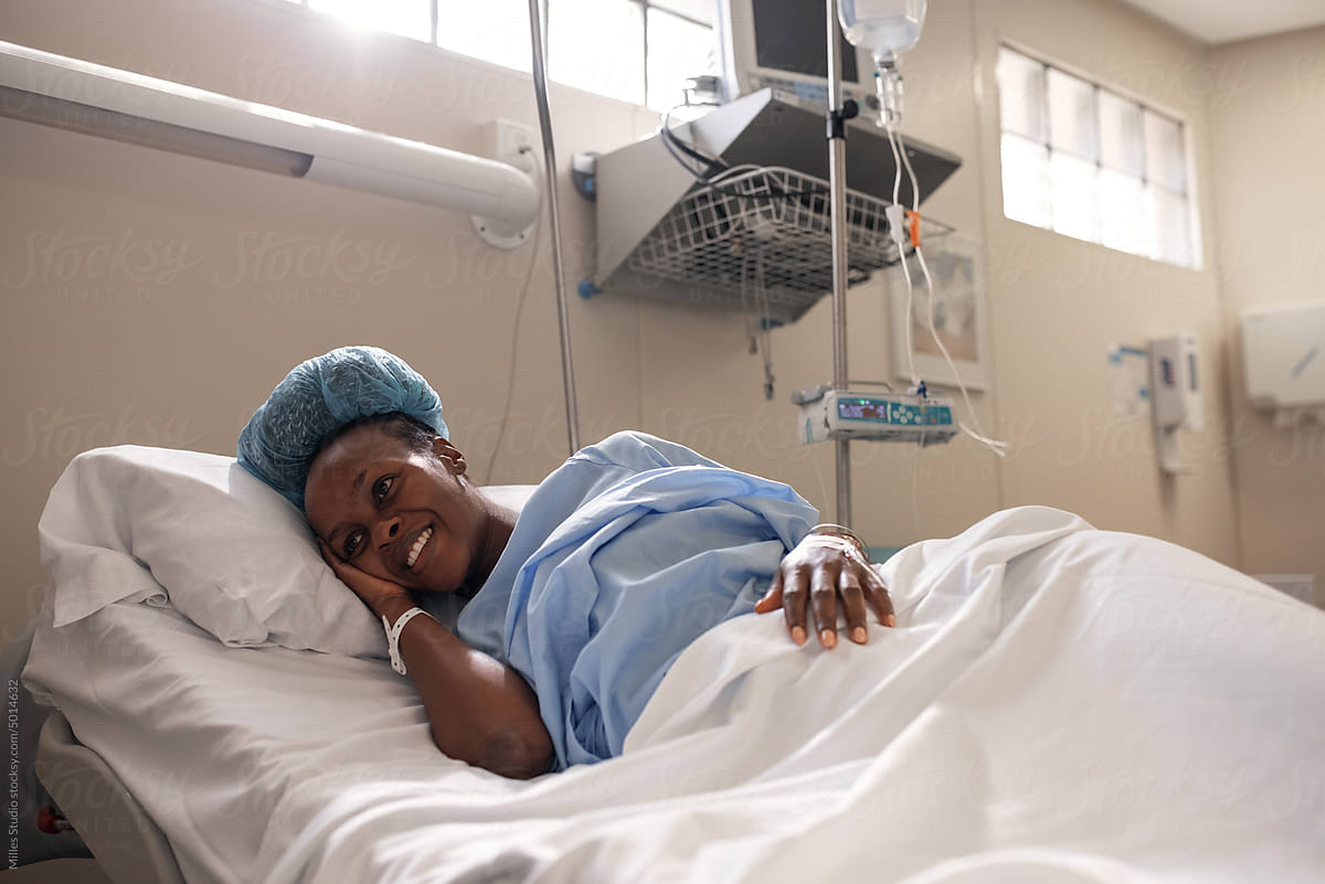 Happy pregnant black woman on hospital bed
