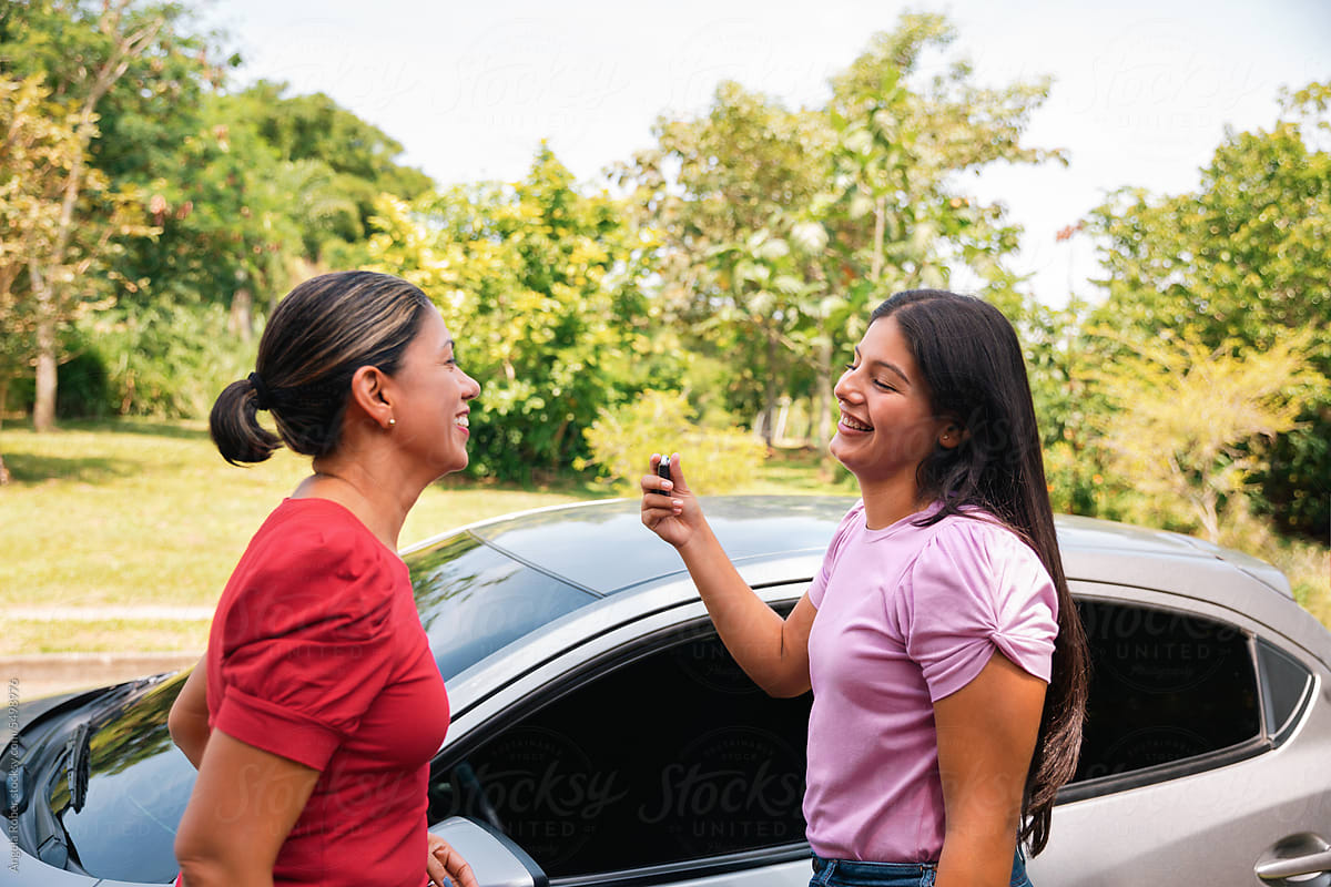 Young woman receiving car keys from her mother