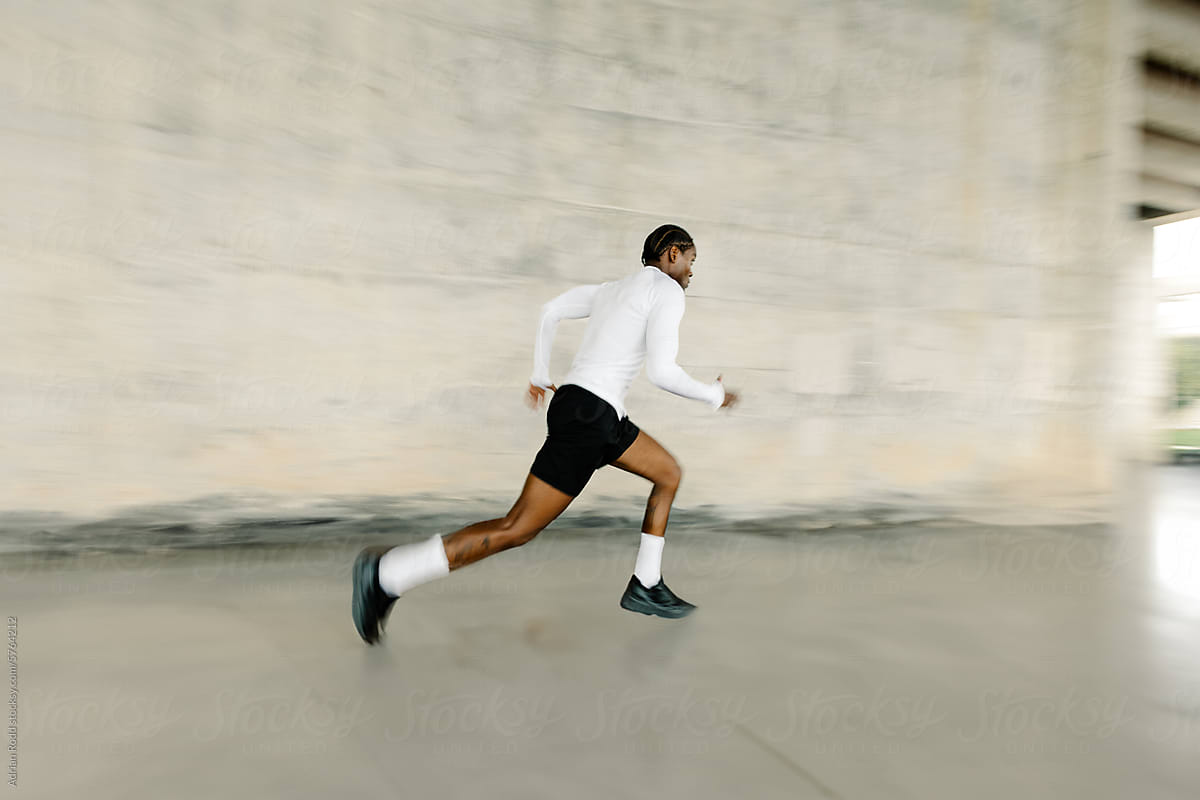 A black man running in an empty street