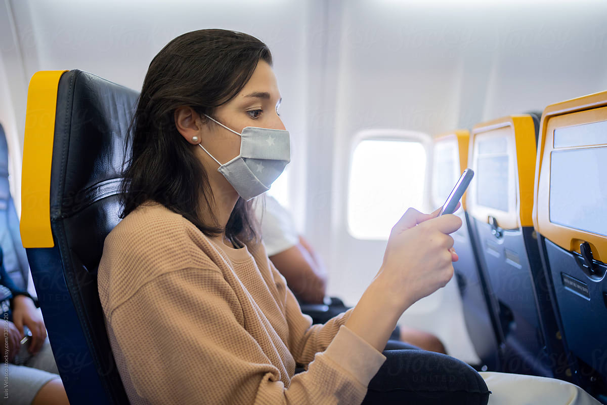 Woman With Mask Flying On A Plane.