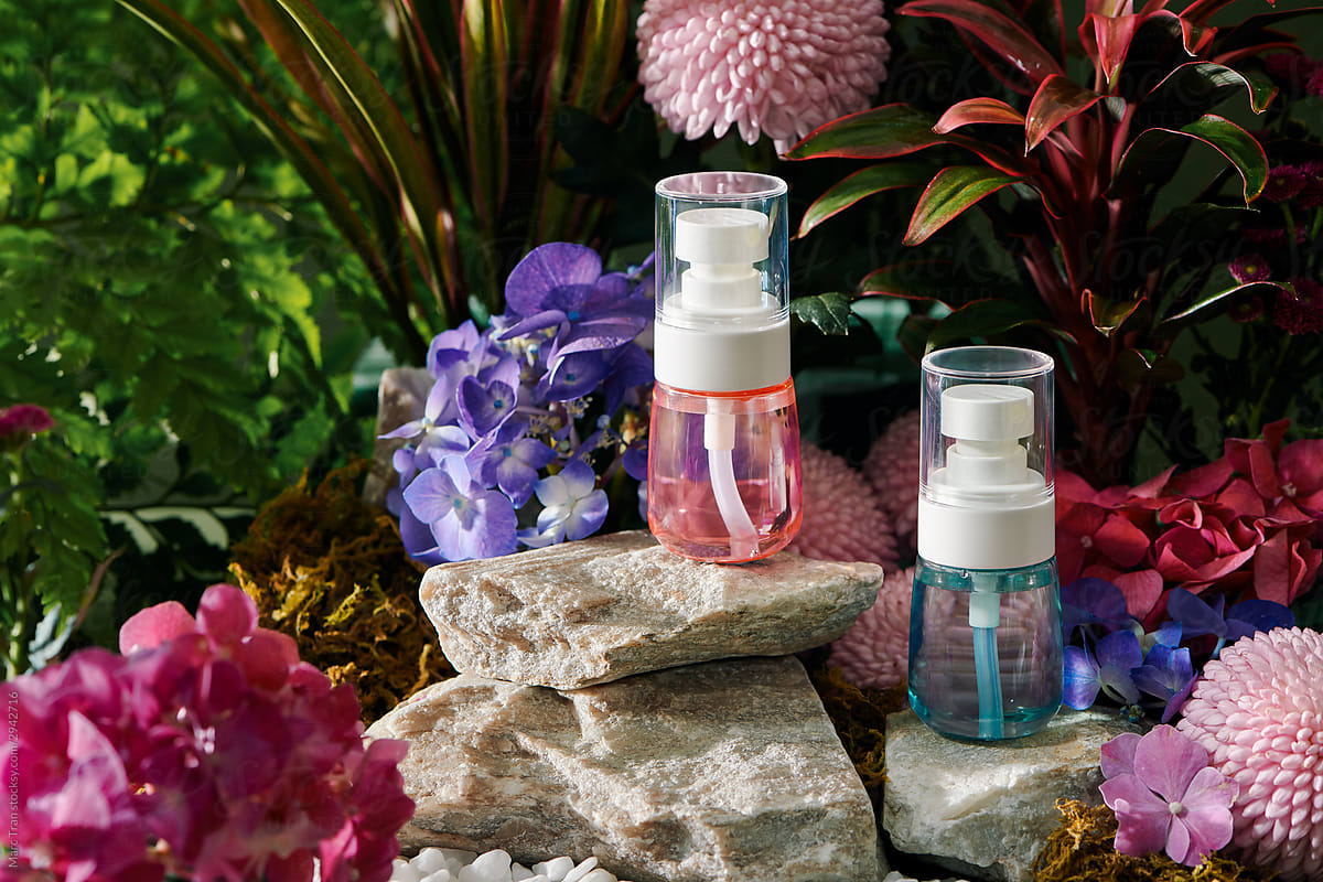 Essential oil bottles with flowers and green freshness