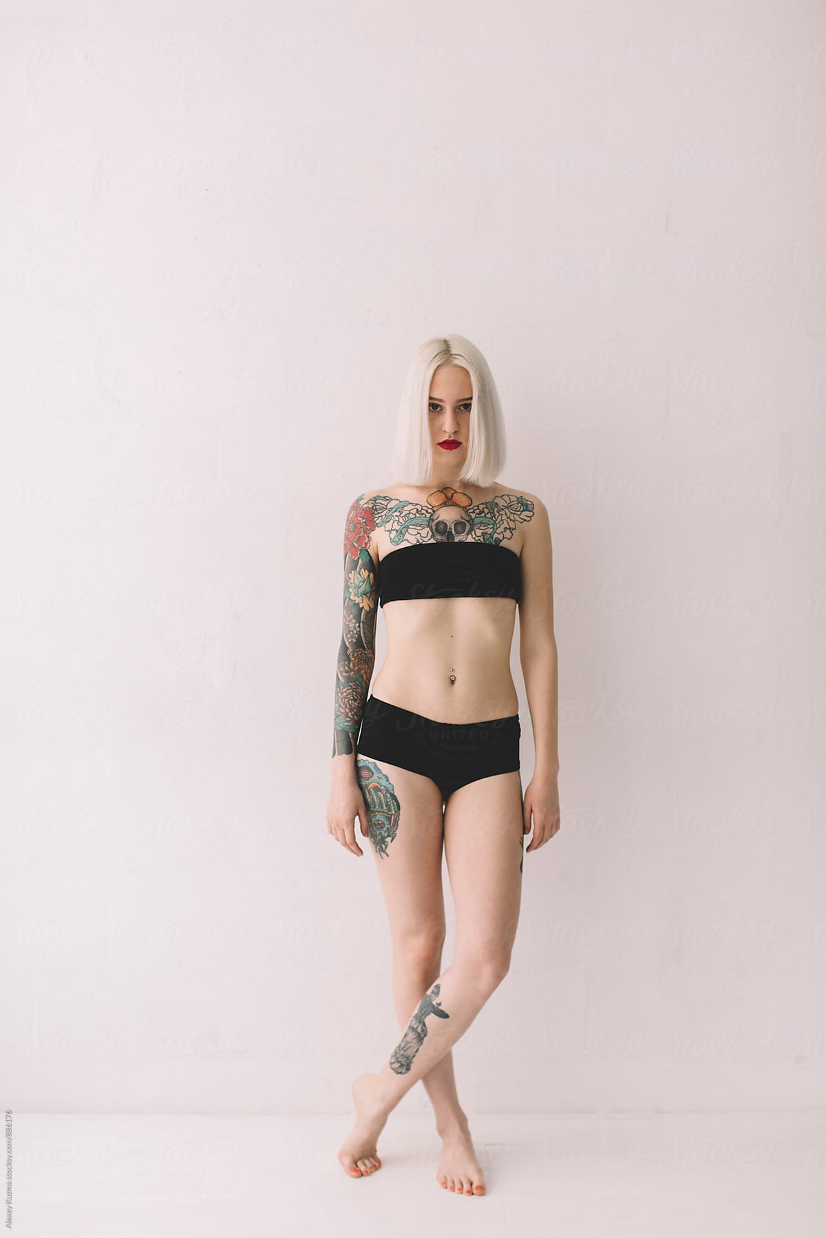 blond woman with tattoos on the white background