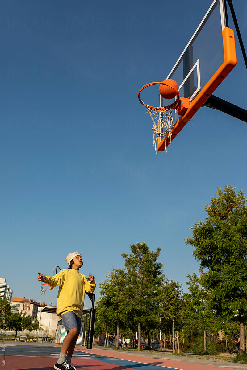Boy making a basketball shot that skims the hoop