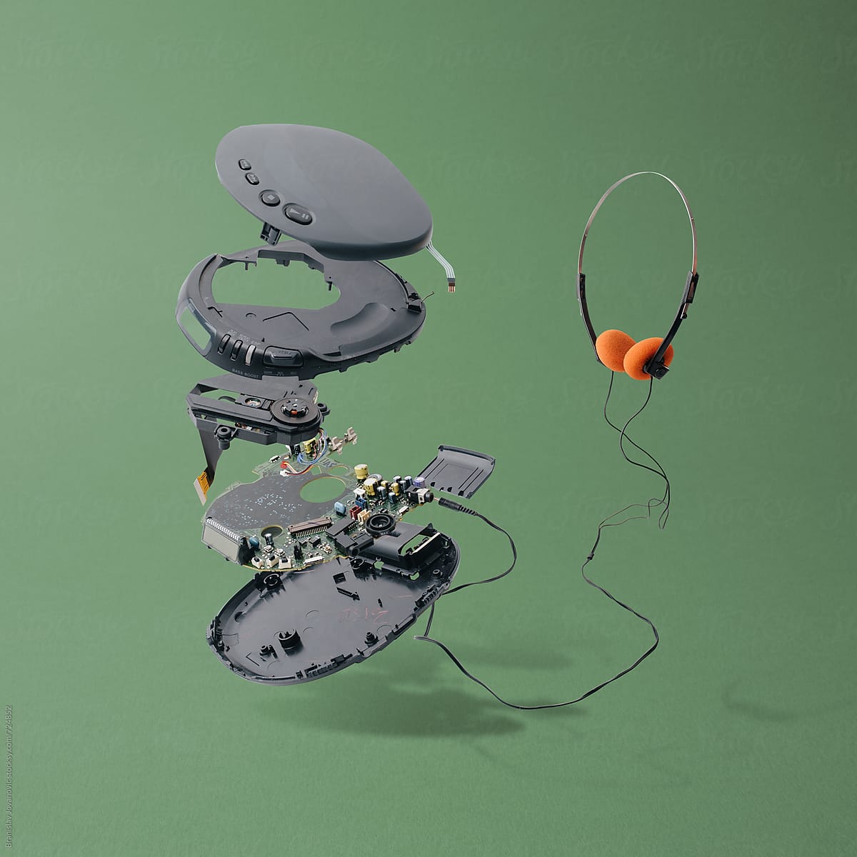 Disassembled Portable CD Player With Headphones On Green Background