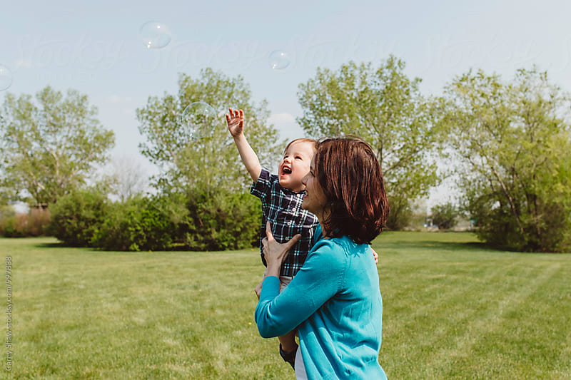 Mother and son catching bubbles and playing outside