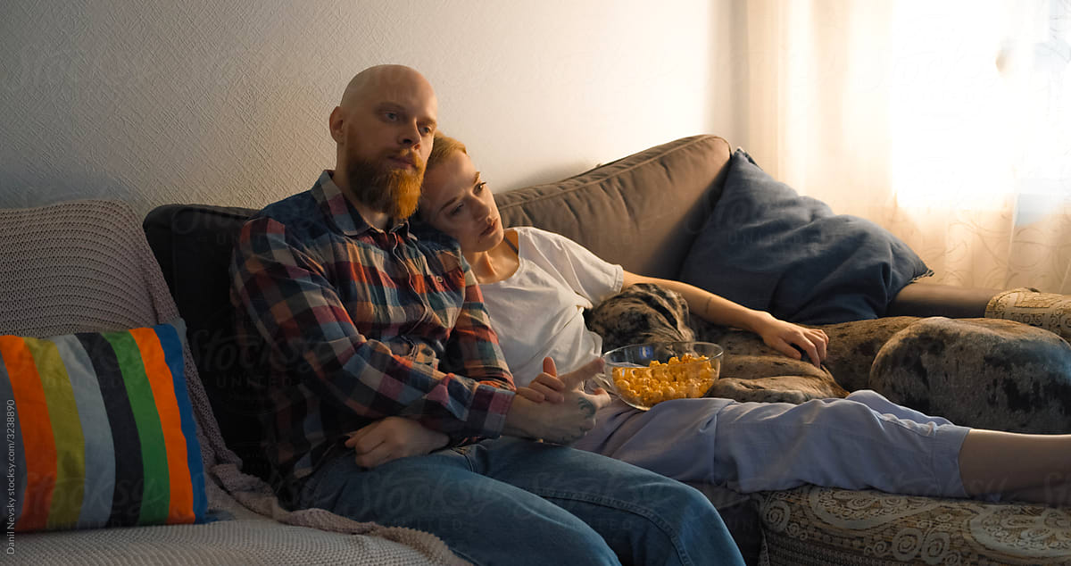 Peaceful couple watching movie with dog