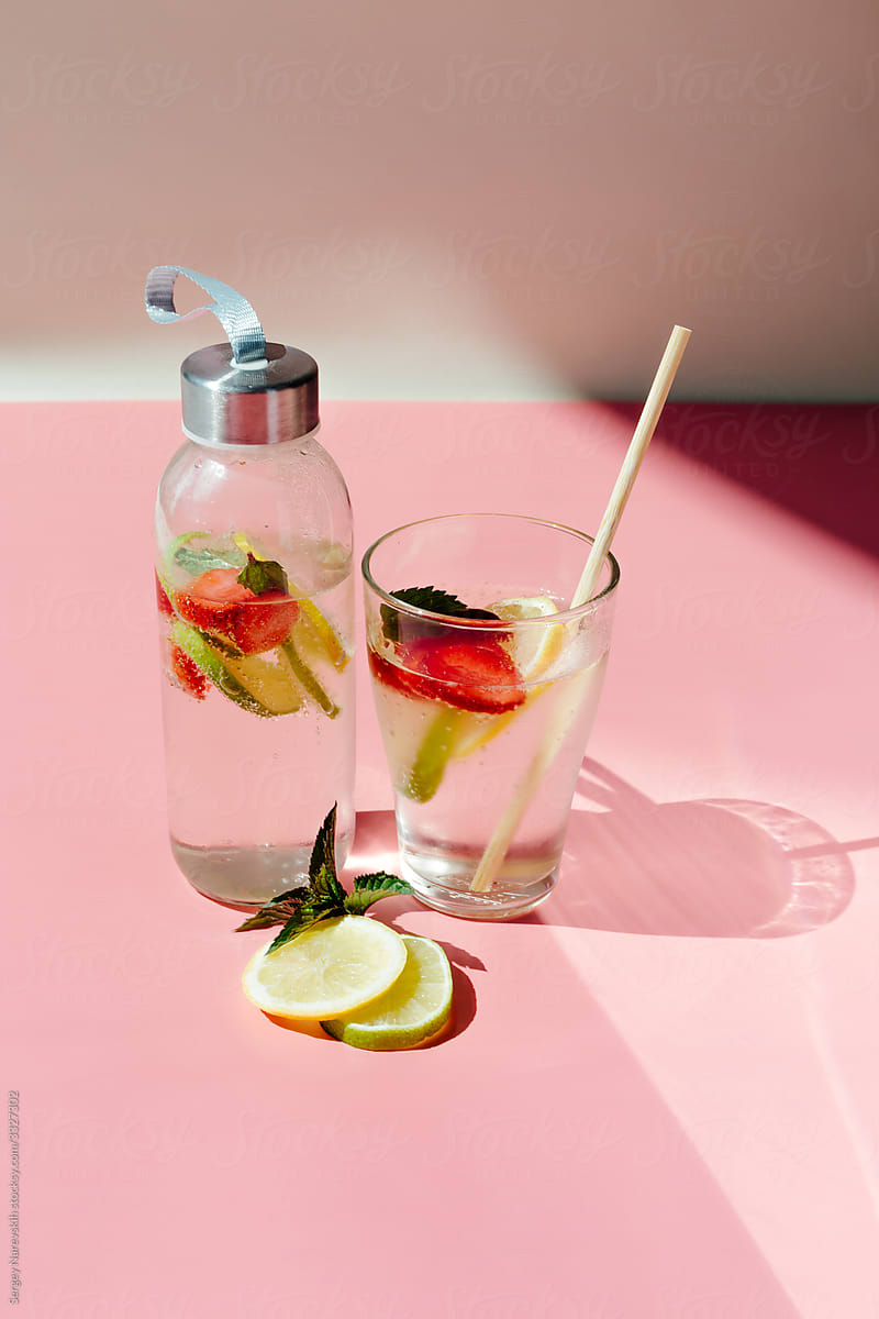 Glass bottle and cup with fruit beverage