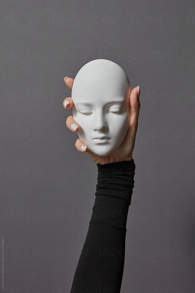 Girl's hand holds the gypsum face sculpture mask