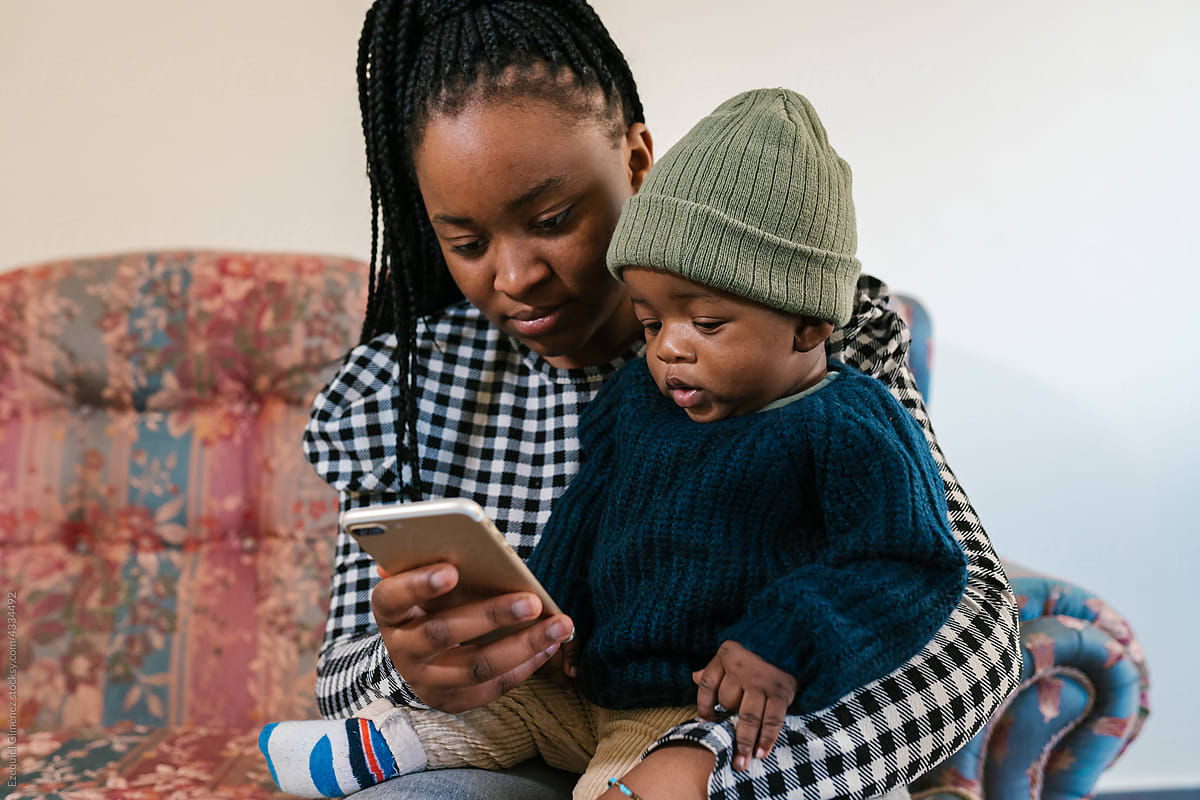 Black mom with baby using cellphone