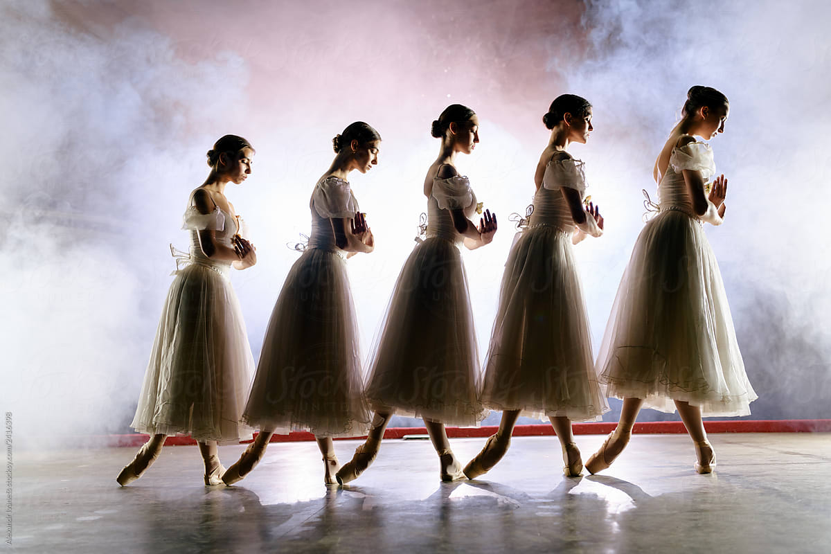 Row of ballerinas in dresses posing on scene