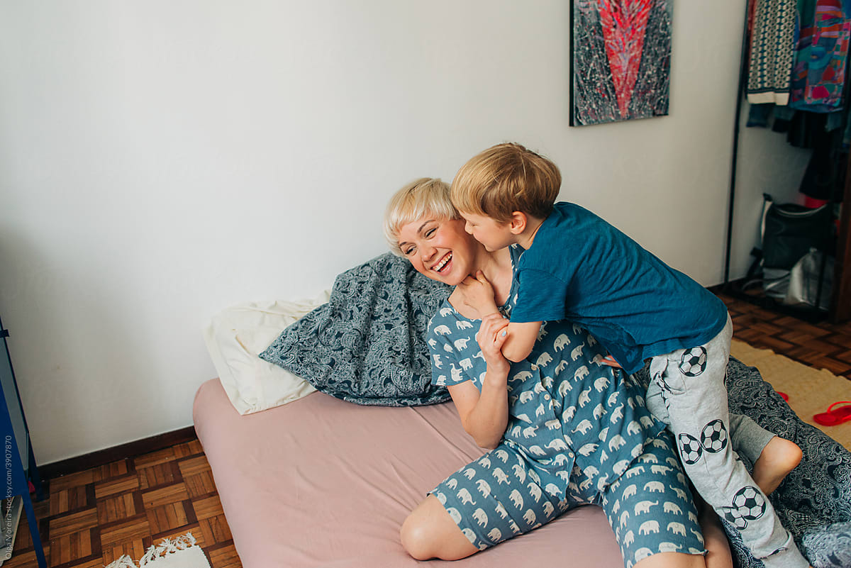 Mother and little son having fun in bed in the morning