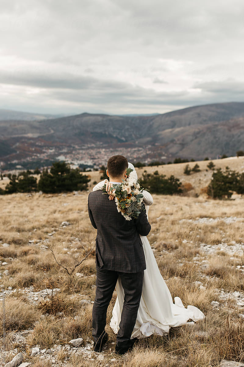 Bride and groom hugging in the mountains