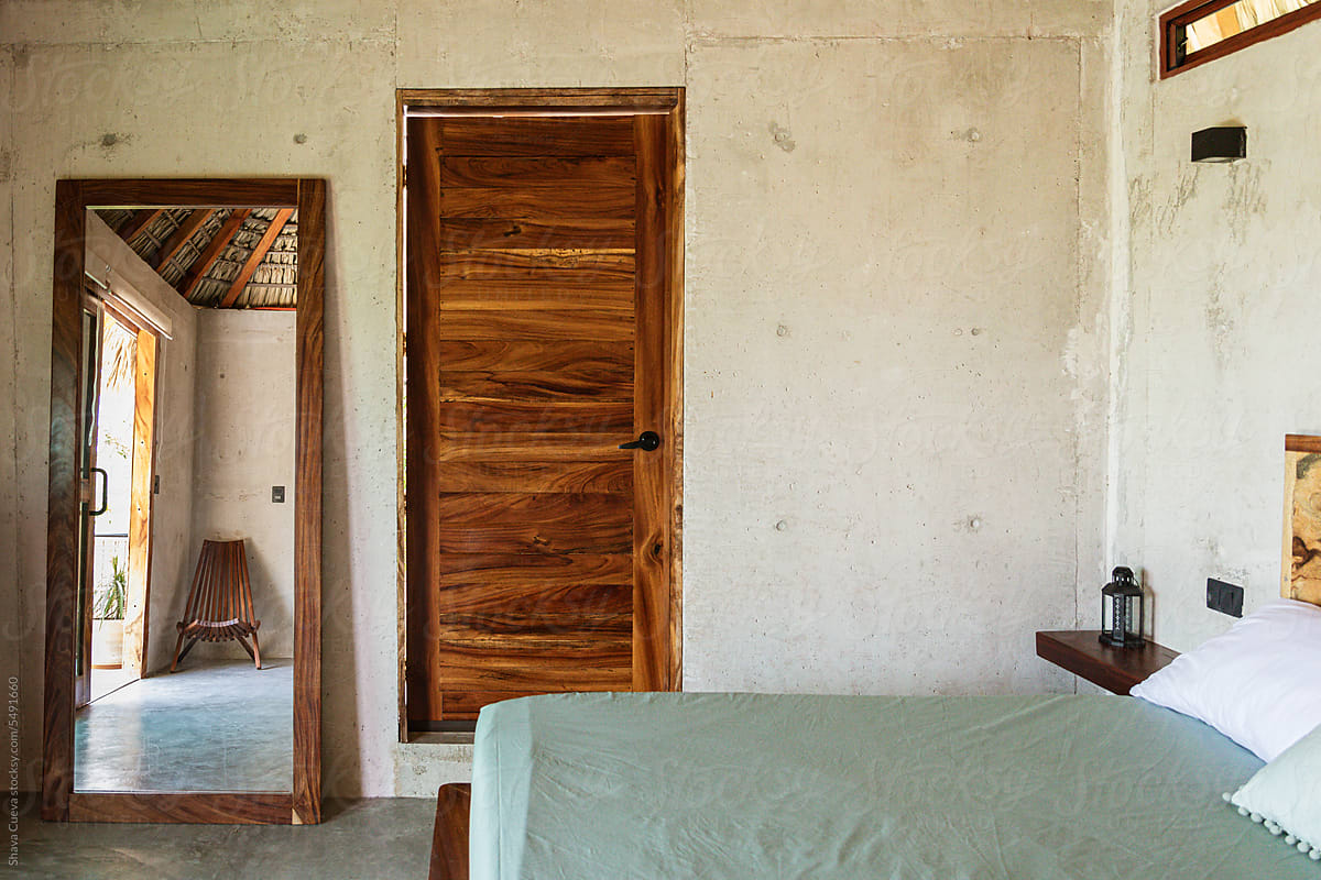 The interior of a room in a beach house with an empty bed