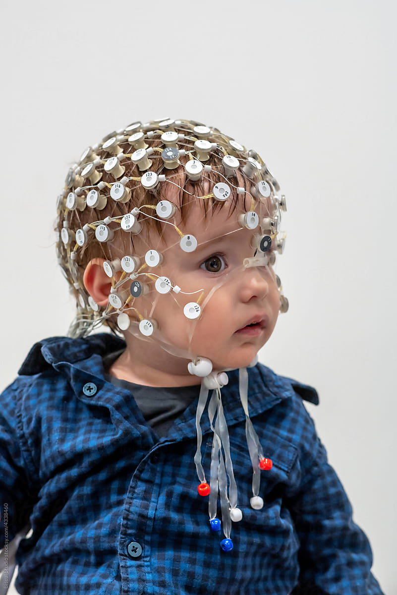 Portrait of a toddler in EEG cap in a lab