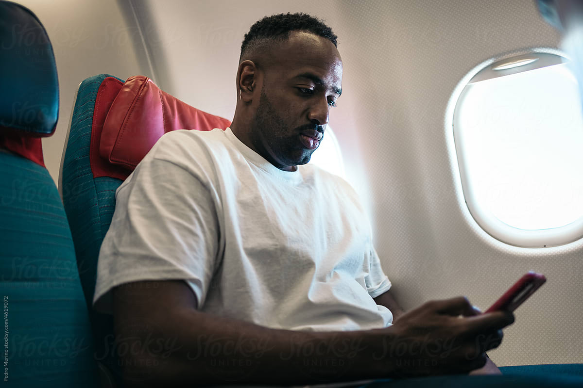 Young man using a smartphone during a flight