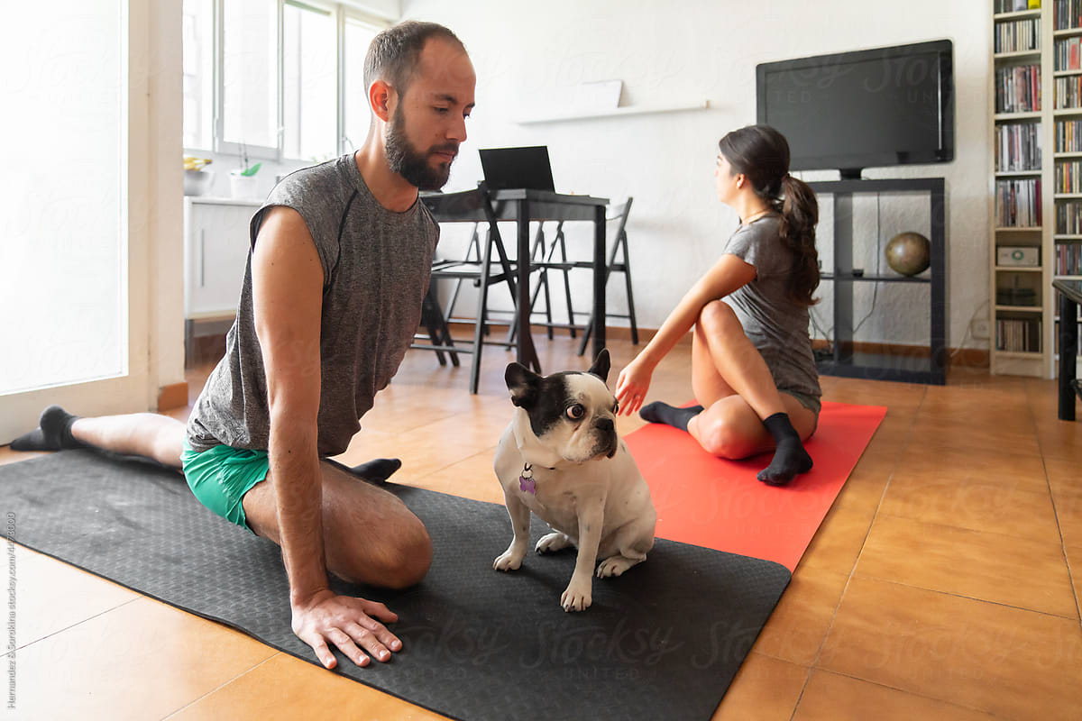 Couple Performing Yoga In Living Room