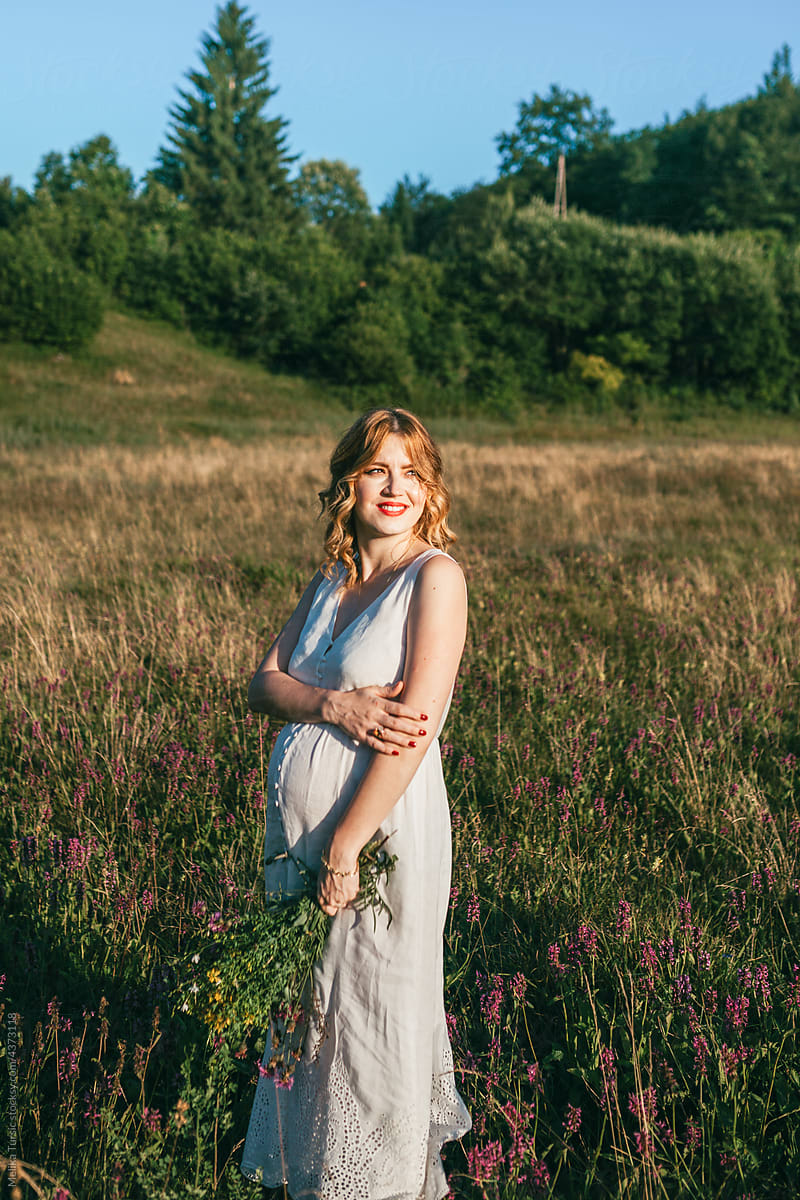 Pregnant woman looking into distance while in nature