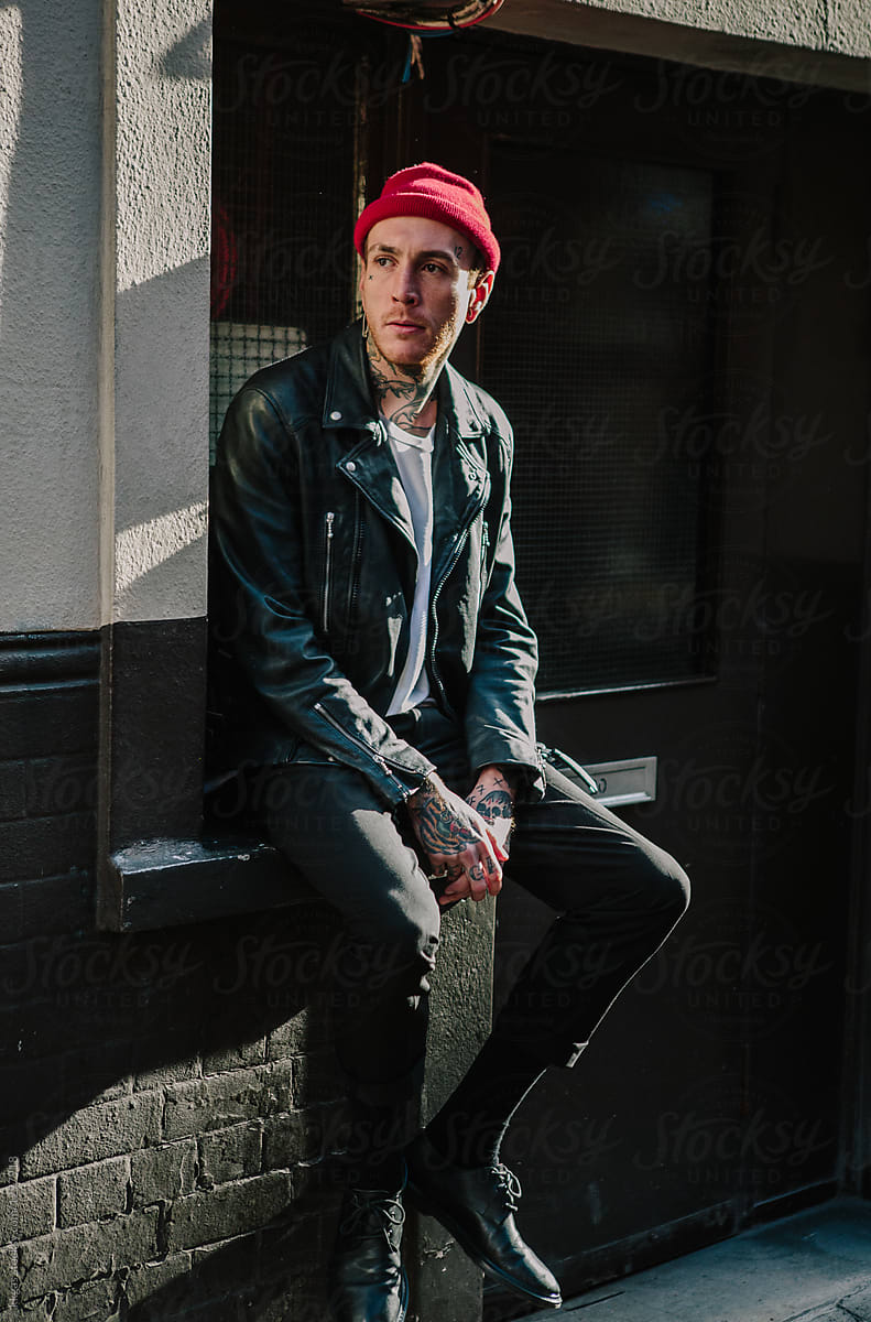 Punk man wearing leather jacket and beanie hat in London