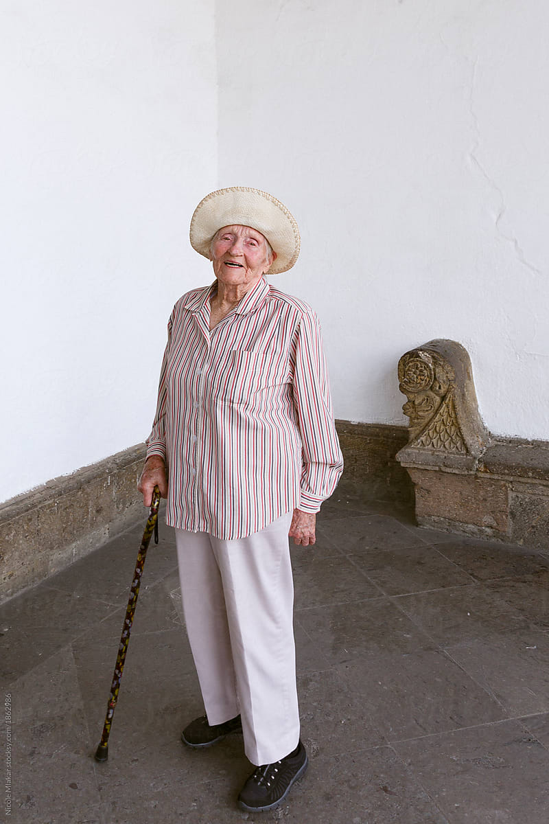 Senior woman smiling with cane and sunhat in Guadalajara, Mexico