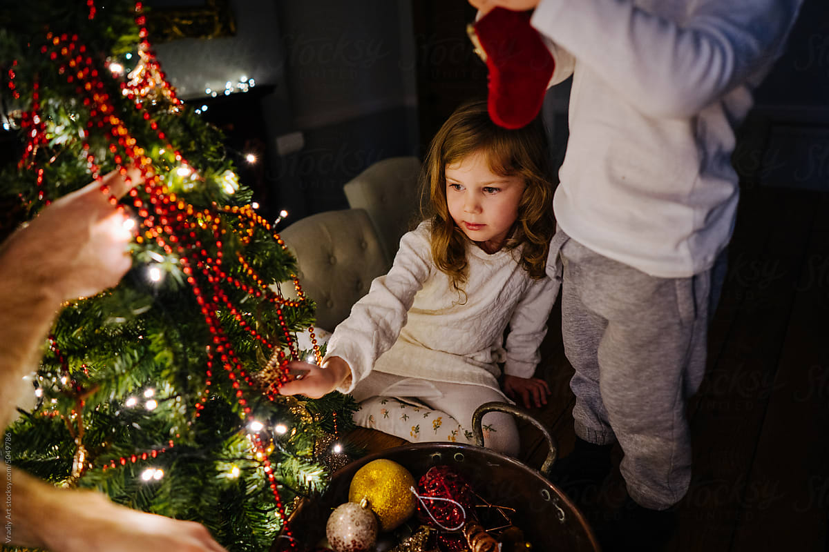 Children decorate little Christmas tree