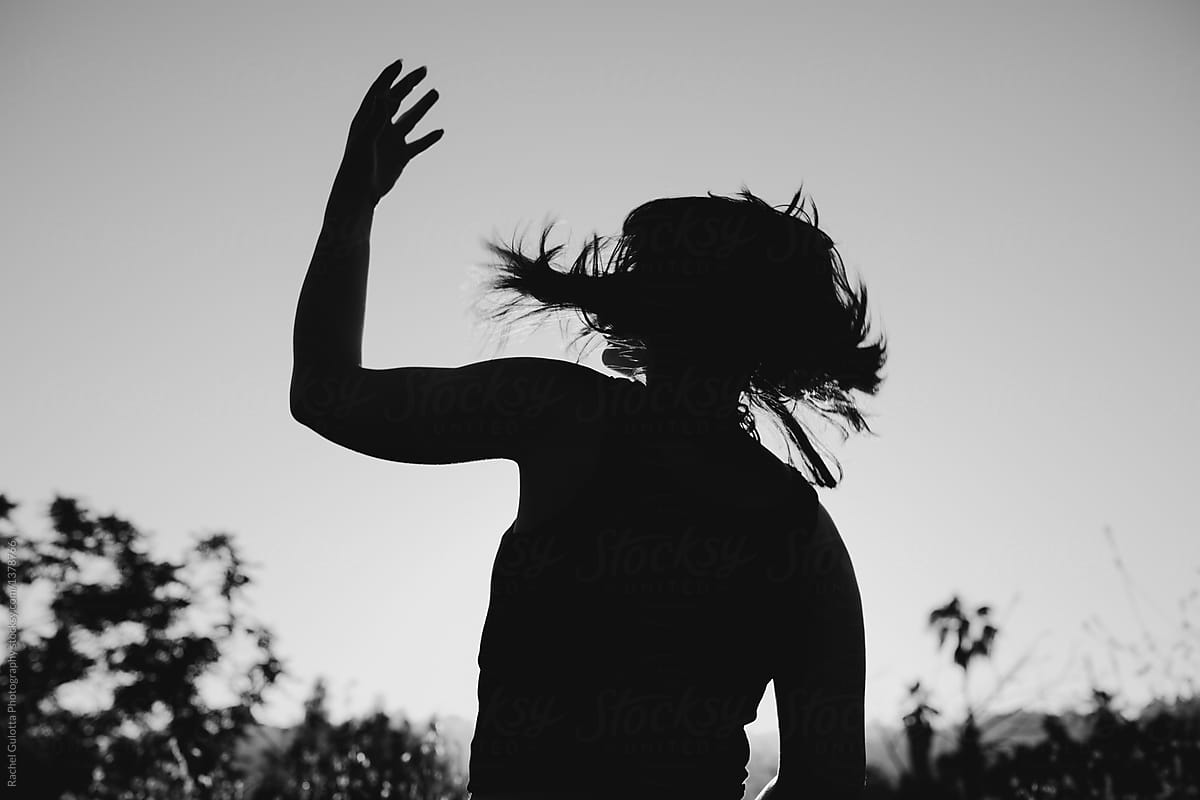 Black and White Photo of a Young Woman Throwing Her Hair in the Wind